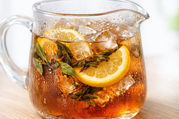 Iced Tea Pitcher with Tea Leaves and Lemon on Wooden Table-1