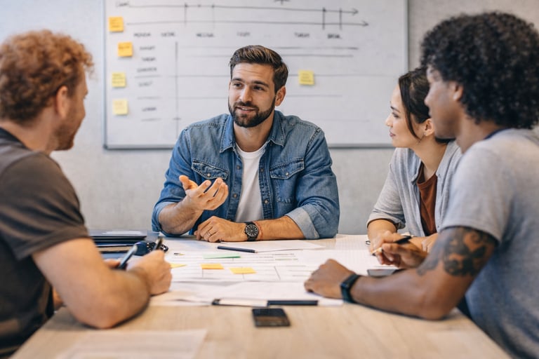 Startup team in discussion about deadlines, owners, and next steps after a meeting.